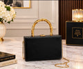 Luxury Black Structured Handbag with Gold Bamboo Handle & Chain Strap